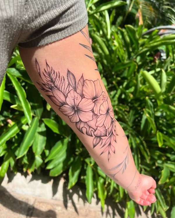 Black and grey botanical floral tattoo on forearm