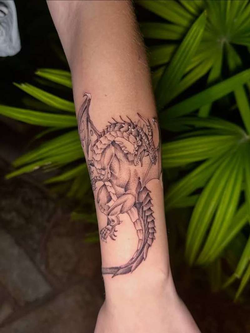 Black and grey illustrative dragon tattoo on forearm