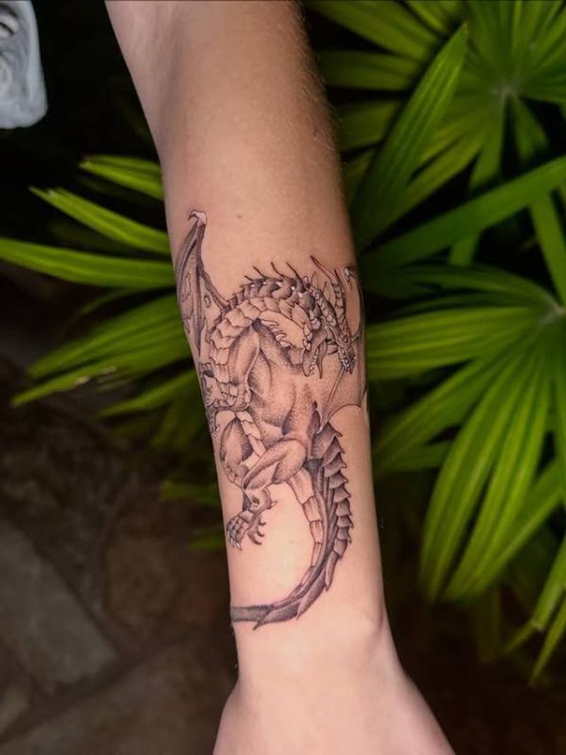 Black and grey illustrative dragon tattoo on forearm