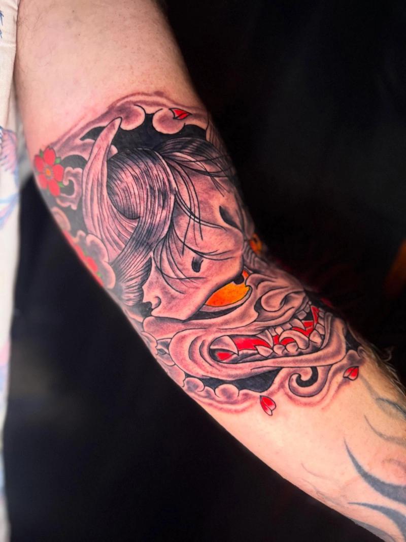japanese traditional forearm tattoo with hannya mask and cherry blossoms