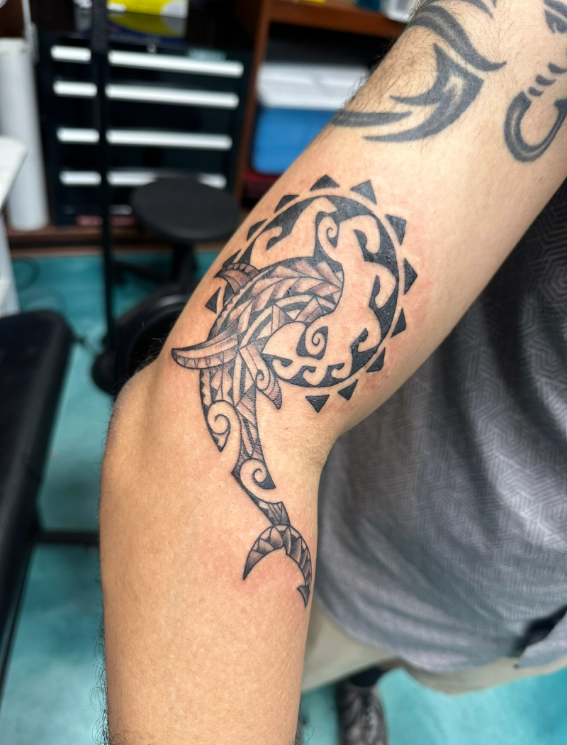 Blackwork tribal shark tattoo with geometric patterns on forearm