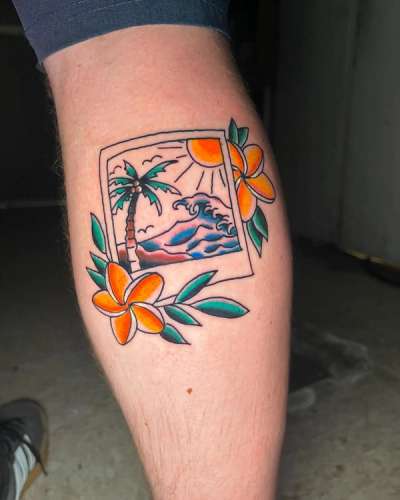 Colorful tropical scene tattoo on calf with palm tree and flowers