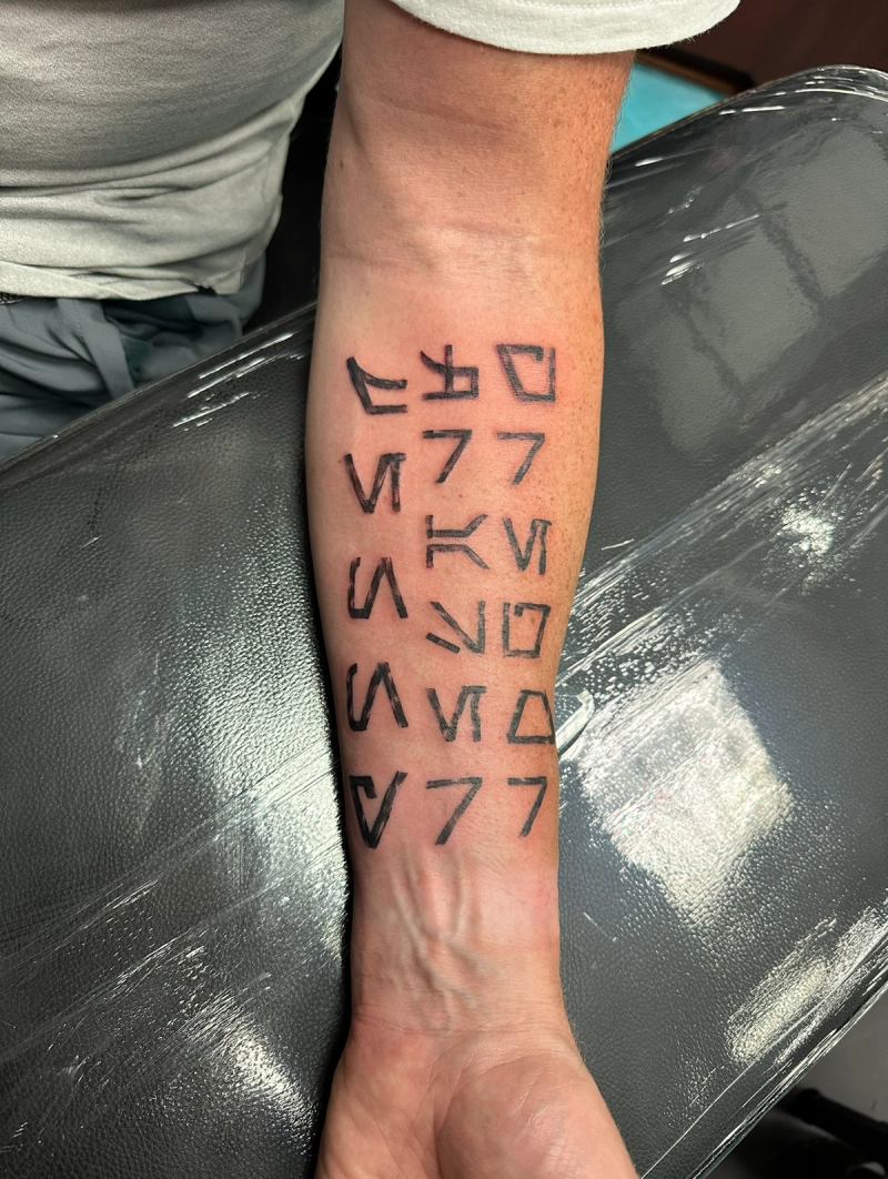 Blackwork geometric symbols on forearm
