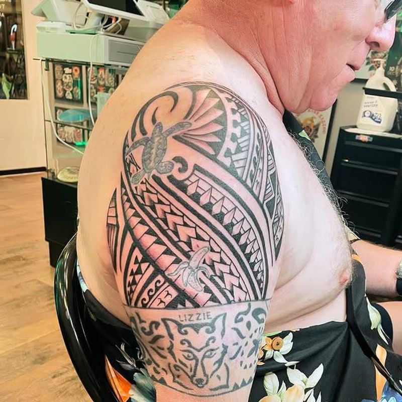 Black and grey tribal geometric tattoo on upper arm