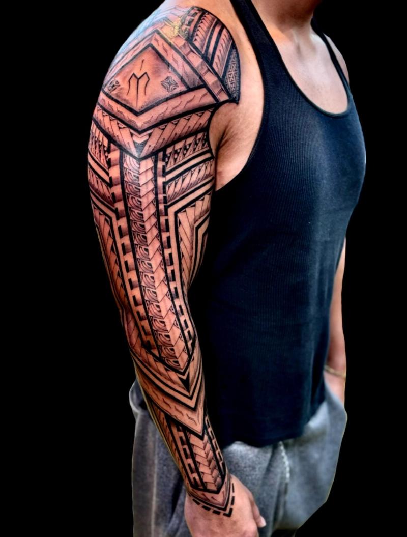 Black and grey tribal geometric sleeve tattoo on full arm