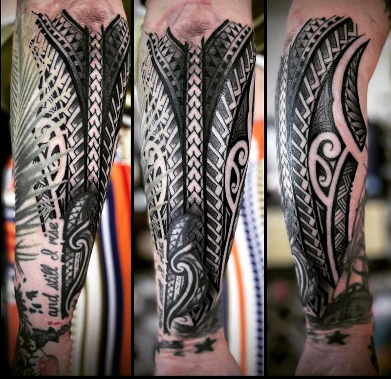 Black and grey tribal pattern tattoo on forearm