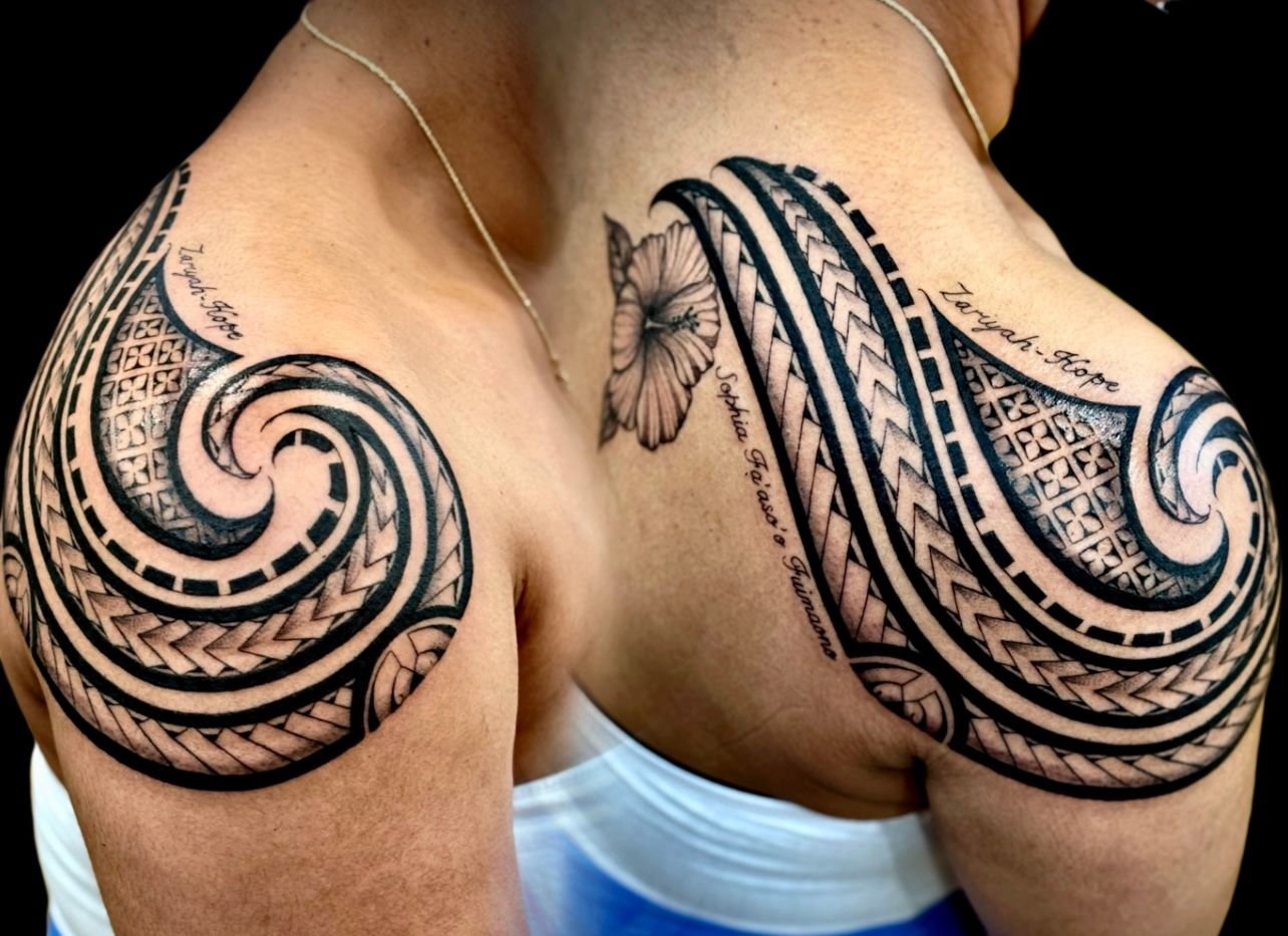 Black and grey tribal tattoo with lettering on shoulder