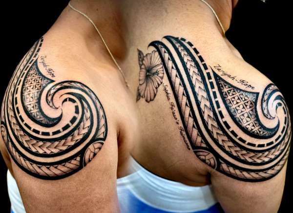 Black and grey tribal tattoo with lettering on shoulder