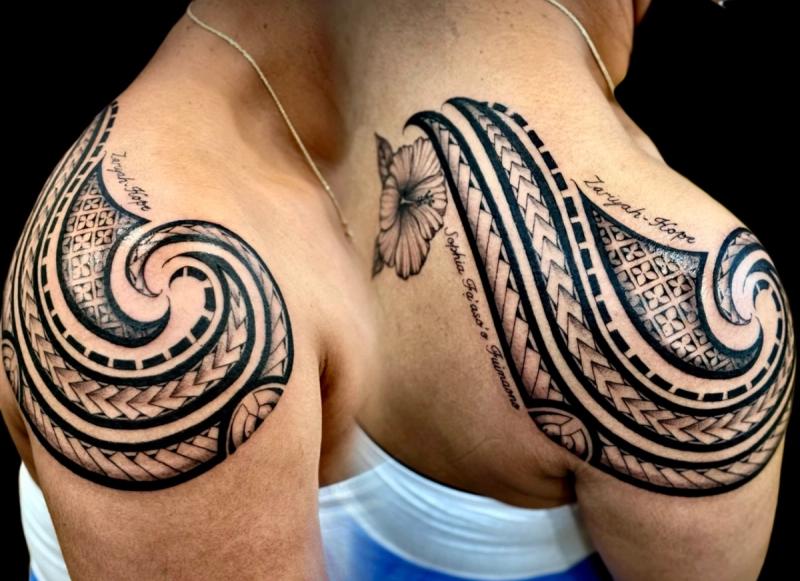 Black and grey tribal tattoo with lettering on shoulder