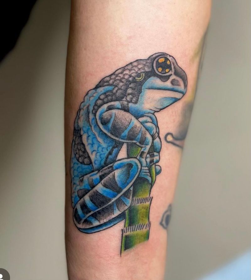 Colorful frog holding bamboo tattoo on forearm