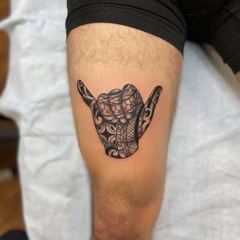 tribal shaka hand tattoo on a thigh