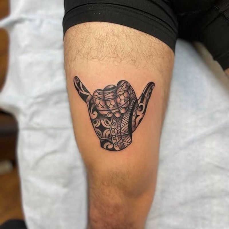 tribal shaka hand tattoo on a thigh