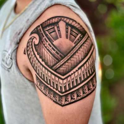 Black and grey tribal geometric tattoo on upper arm