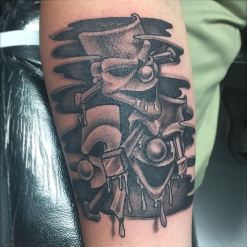 Black and grey illustrative clown tattoo on forearm
