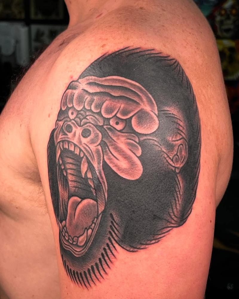 Black and grey illustrative gorilla face on upper arm