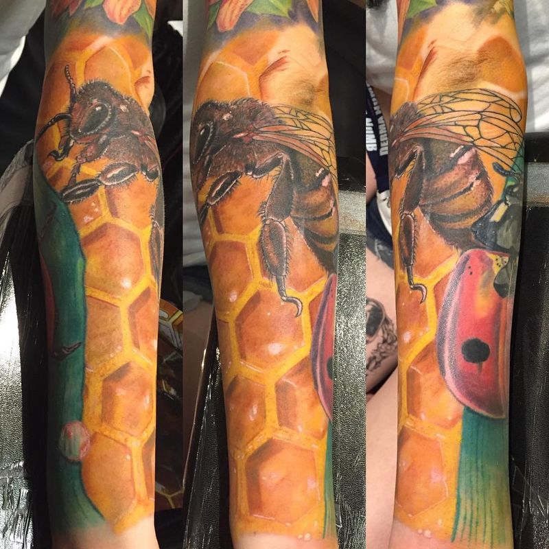 realistic bee and honeycomb tattoo on forearm