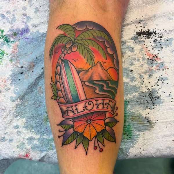 Colorful traditional style tattoo of a Hawaiian sunset on the calf