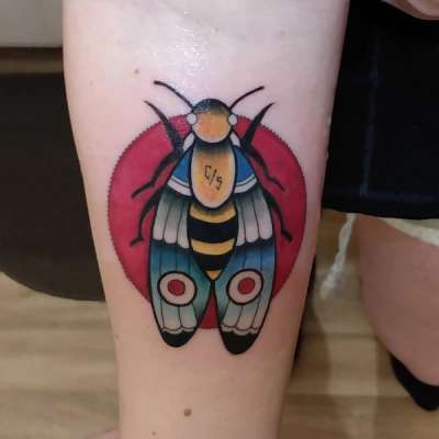 colorful moth tattoo on forearm