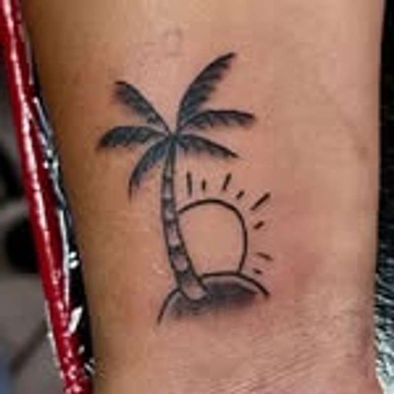 small black and grey palm tree tattoo on forearm