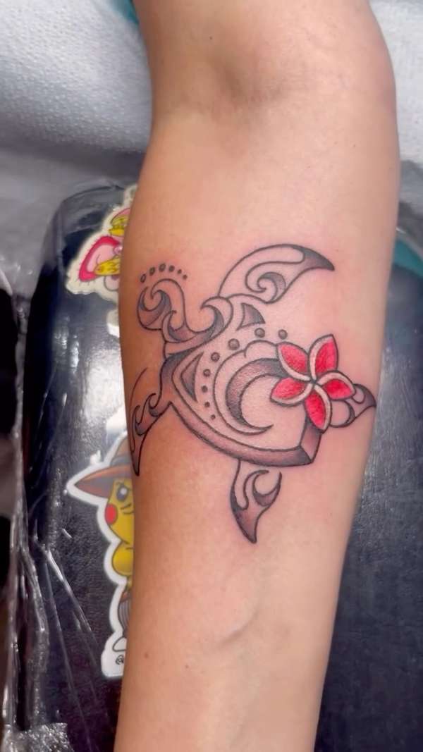 tribal turtle tattoo with floral design on forearm