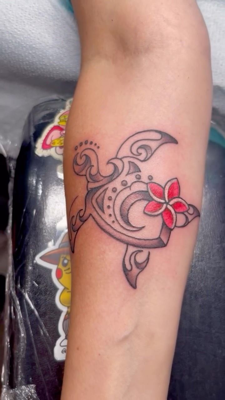 tribal turtle tattoo with floral design on forearm