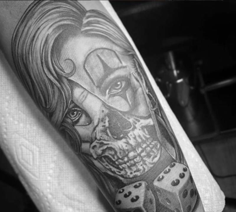Black and grey realistic half-skull and female face tattoo on forearm