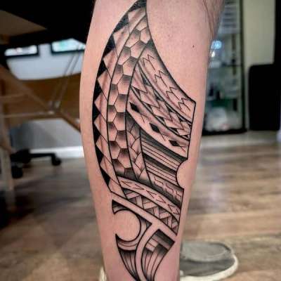 Black and grey geometric pattern tattoo on calf