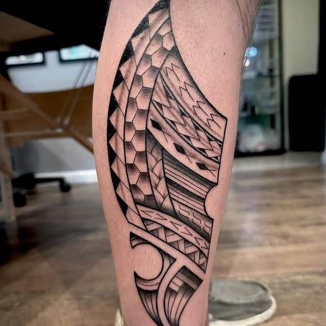 Black and grey geometric pattern tattoo on calf