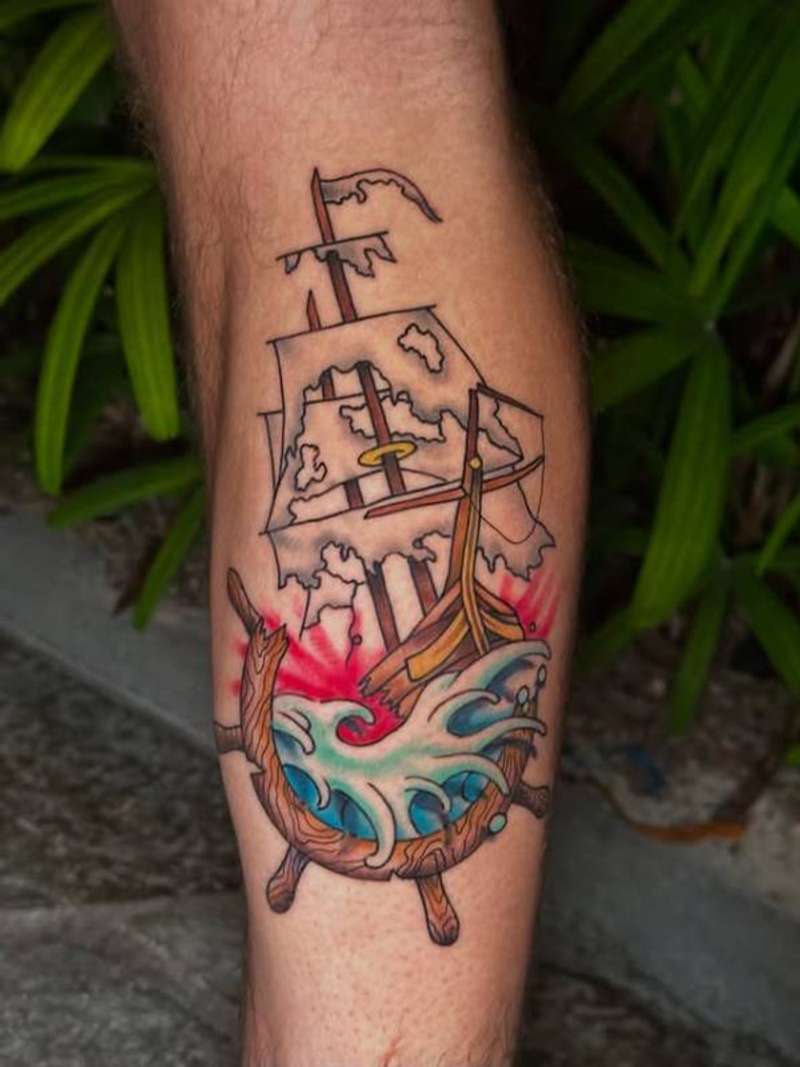 Colorful traditional ship and wave tattoo on calf