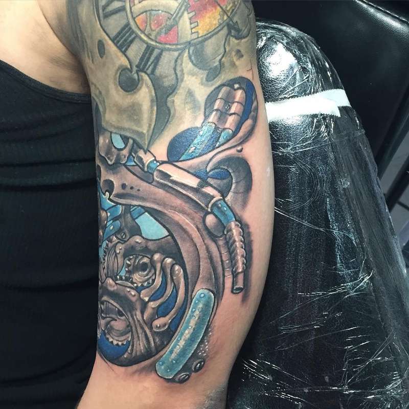colorful mechanical gear tattoo on upper arm