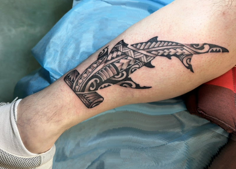 Blackwork tribal shark tattoo on calf