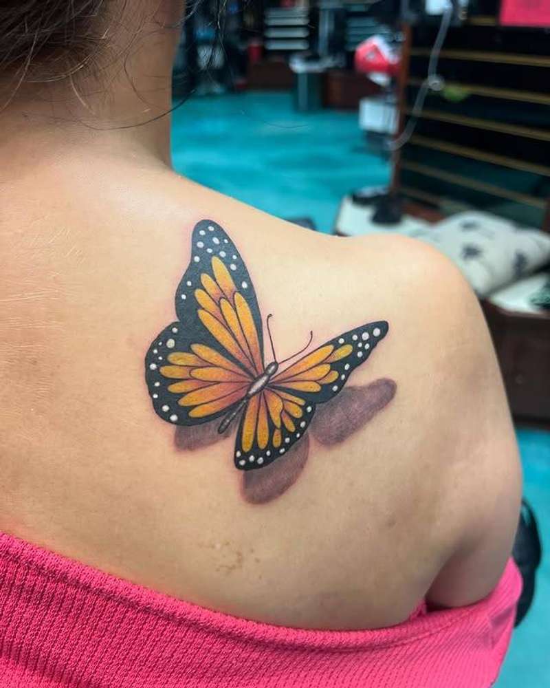 colorful butterfly tattoo on a shoulder
