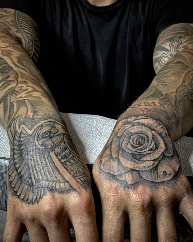 Black and grey illustrative owl and rose tattoos on hands
