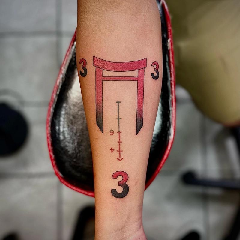 geometric tattoo with red and black patterns on forearm