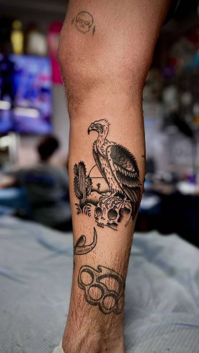 illustrative vulture and skull tattoo on calf
