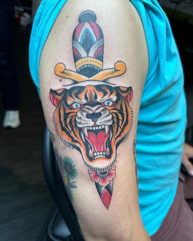 colorful traditional tiger and dagger tattoo on upper arm