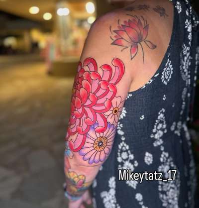 colorful japanese chrysanthemum forearm tattoo with lotus accent