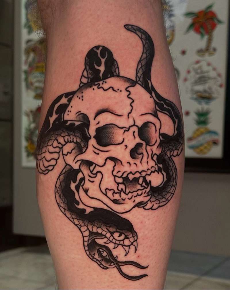 blackwork tattoo of a skull with a snake wrapped around it on a calf