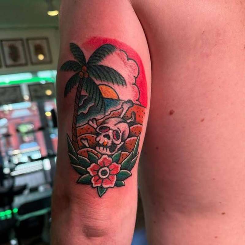 Traditional colorful skull and palm tree on upper arm