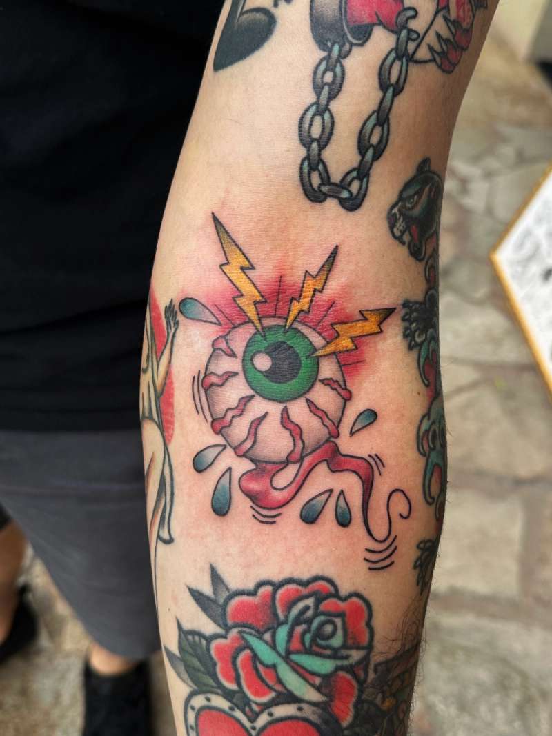 Colorful traditional eyeball with lightning on forearm
