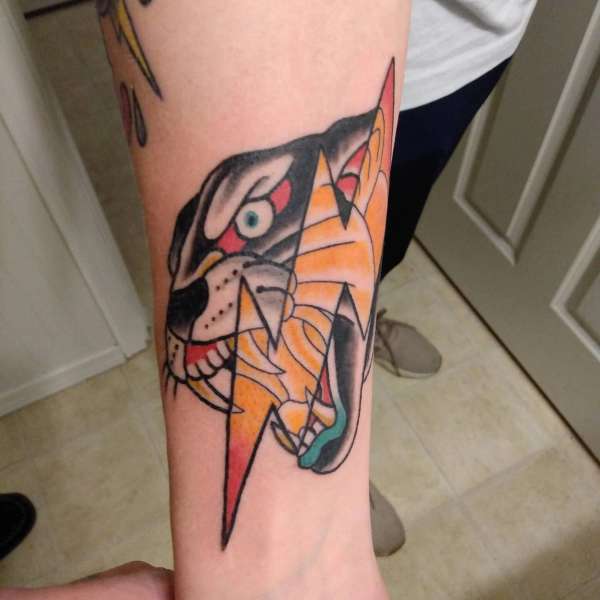 colorful panther tattoo with geometric shapes on forearm