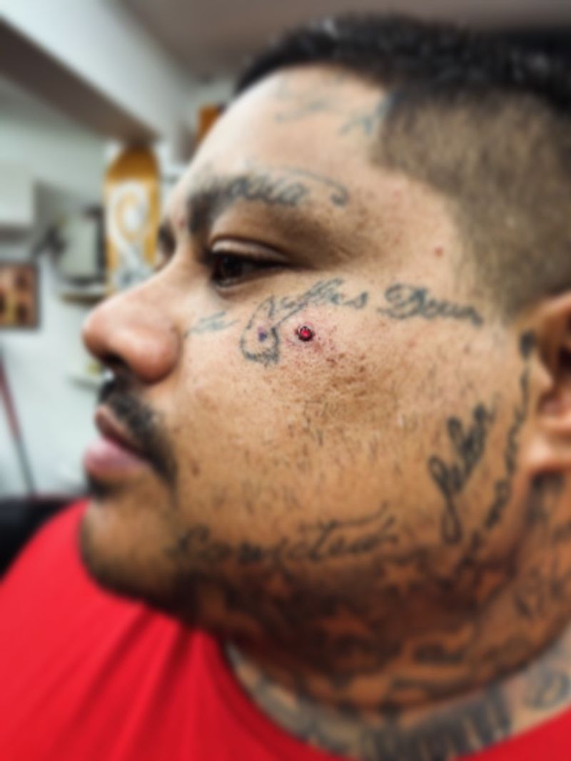 script lettering tattoo on face