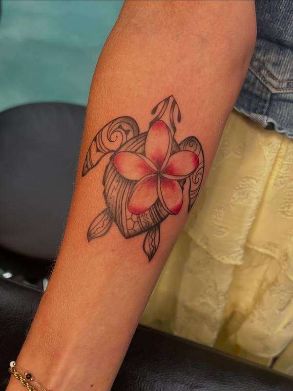 tribal illustrative turtle and flower tattoo on forearm