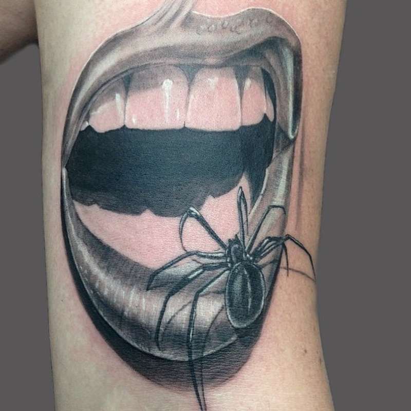 Black and grey realistic spider and open mouth tattoo on upper arm