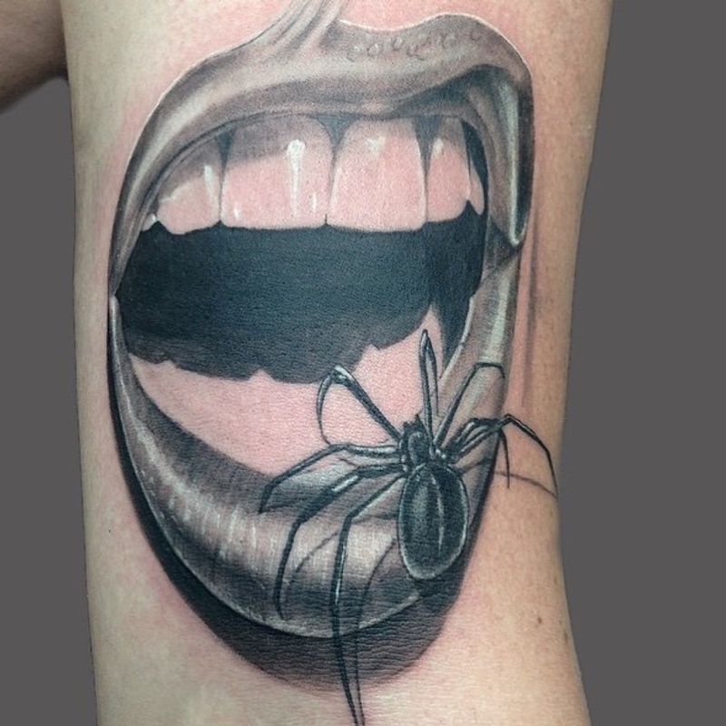 Black and grey realistic spider and open mouth tattoo on upper arm