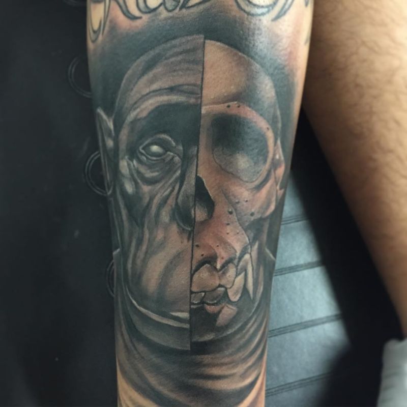 Black and grey realistic split face skull tattoo on forearm