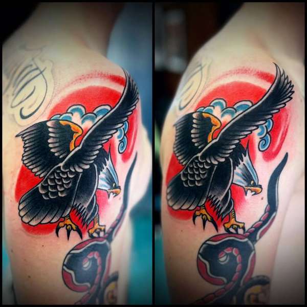 Colorful traditional eagle and snake tattoo on upper arm