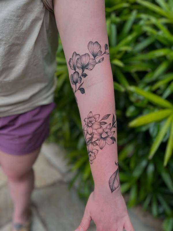 black and grey floral tattoo on forearm