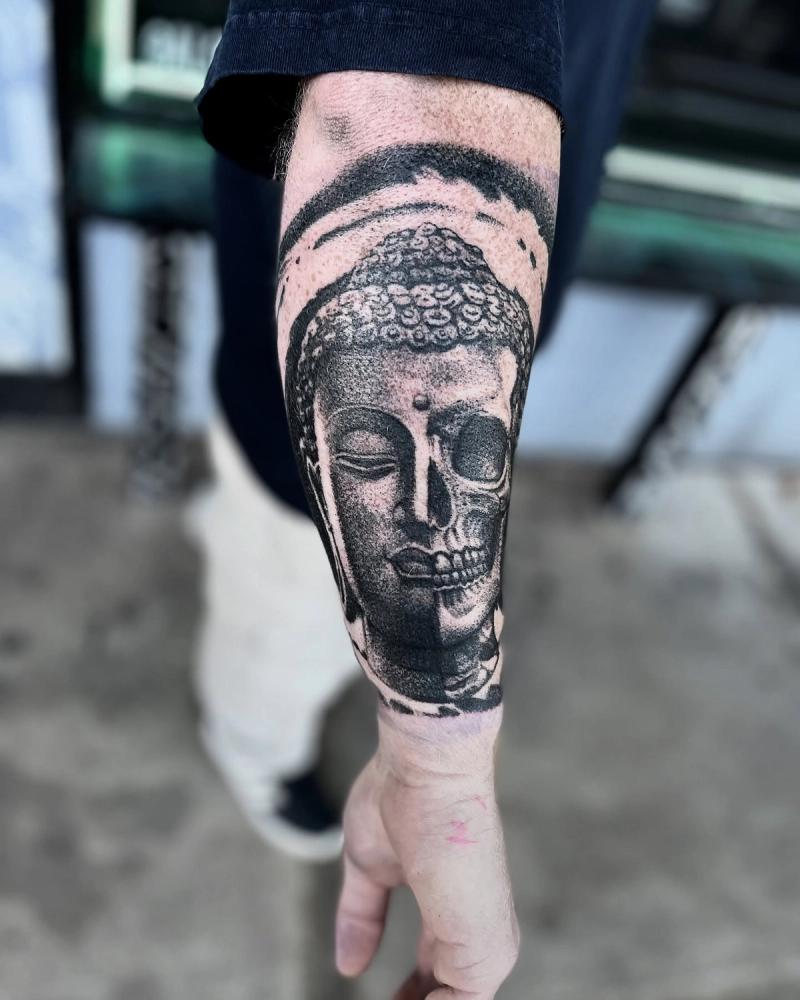 black and grey buddha skull forearm tattoo with dotwork shading
