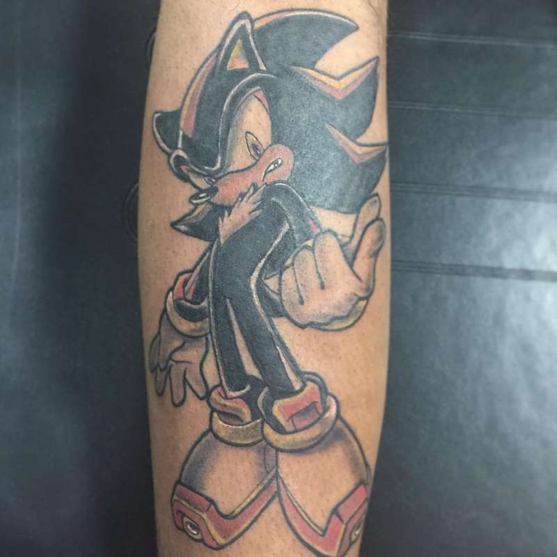 colorful illustrative tattoo of a sonic character on a forearm